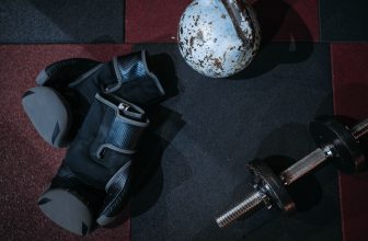 Side by side comparison of dumbbells and kettlebells on a gym floor.