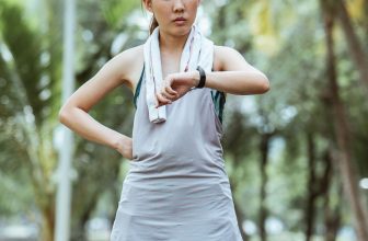 Person checking fitness stats on a smartwatch during an outdoor running workout.