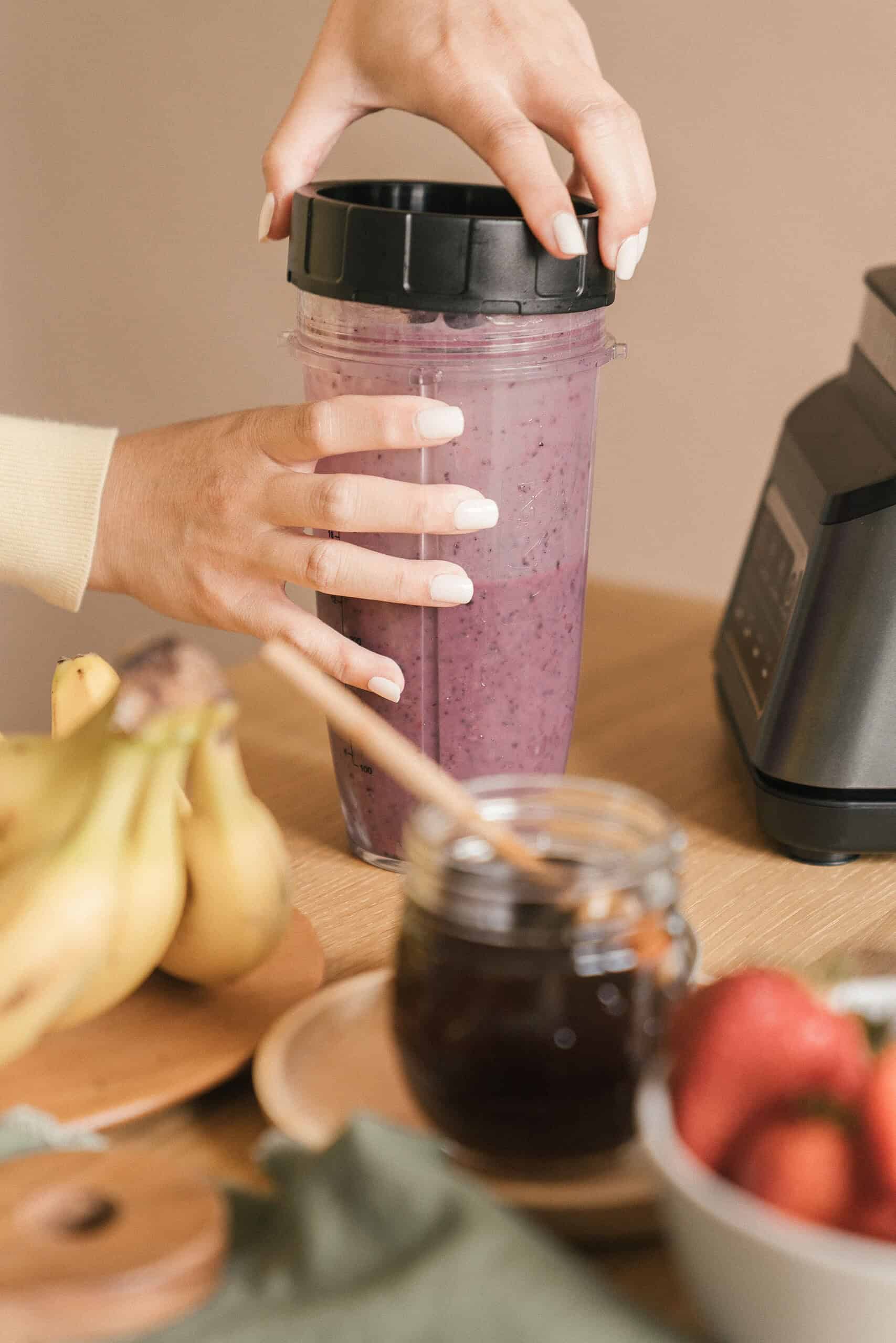 Protein shake on a kitchen counter next to fresh fruit .