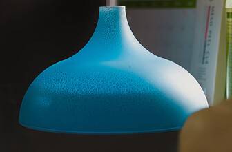 Ultrasonic aromatherapy diffuser emitting a soft mist on a bedroom nightstand next to essential oils.