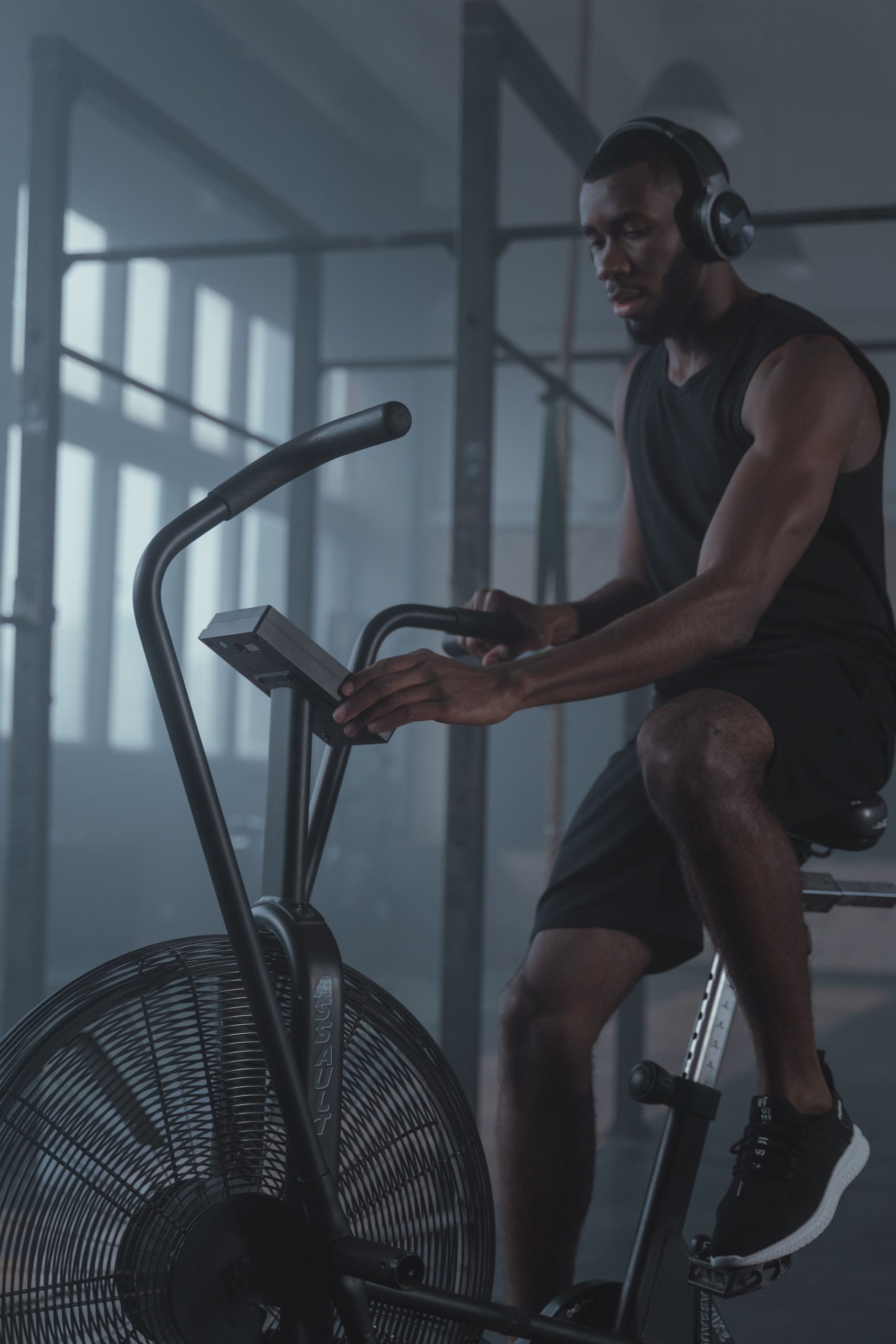 Man pedaling a magnetic upright exercise bike during a home cardio workout session.